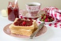 Breakfast of bread toasts with butter and strawberry-rhubarb jam, served with tea. Rustic style. Royalty Free Stock Photo