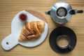 Black coffee with creama made by Moka pot home brew in black espresso cup served with delicious buttery croissant and strawberry j Royalty Free Stock Photo