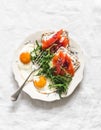 Breakfast, brunch plate - fried eggs, arugula salad, crispy bread curd cheese smoked salmon sandwiches on a light background, top