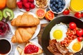 Breakfast buffet full continental with fried eggs, bacon, fruits, toast, croissants, berries, coffee and orange juice Royalty Free Stock Photo