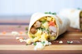 breakfast burrito cut in half, showing eggs, sausage, and cheese filling