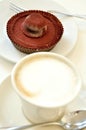 Breakfast with cappuccino and chocolate cake on a white background Royalty Free Stock Photo