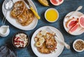 Breakfast - caramel french toast with banana, cottage cheese with granola and pomegranate, fresh grapefruit on a blue background.