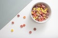 Breakfast cereal concept, Colorful ring cereals in bowl and falling on grey and white background Royalty Free Stock Photo