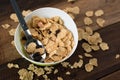 Breakfast cereal cornflakes in a bowl on a wooden table background Royalty Free Stock Photo