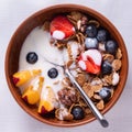 Breakfast of cereals and fruits with yoghurt in Clay bowls on a white tablecloth Royalty Free Stock Photo