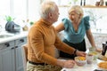 Happy contended beaming nice-appealing attractive elderly spouses talking during breakfast