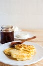 Breakfast: cheesecakes, soft cheese, fresh curd and plum jam in jar and on wooden spoon on wooden table. Royalty Free Stock Photo