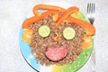 Breakfast for a child is decorated in the form of a funny face in a plate