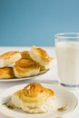 Breakfast with cinnamon buns and glass of milk on a blue background. Royalty Free Stock Photo