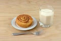 Breakfast of cinnamon roll and glass of kefir milk