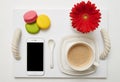 Breakfast with coffee, macaroons and mobile phone on tray