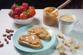 Breakfast with coffee and sandwiches with peanut paste and strawberries