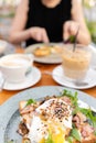 Breakfast and coffee in the summer cafe. Sandwich on a bun brioche with bacon, mushrooms, arugula and poached egg