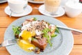 Breakfast and coffee in the summer cafe. Sandwich on a bun brioche with bacon, mushrooms, arugula and poached egg