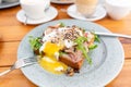 Breakfast and coffee in the summer cafe. Sandwich on a bun brioche with bacon, mushrooms, arugula and poached egg