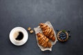 Breakfast - coffee, sweet croissant with chocolate and blueberries.