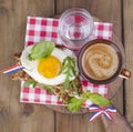 Breakfast with coffee, toasts, butter and jam on wooden background. Above