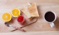 Breakfast with Coffee, toasts, oranges and strawberry jam on wooden table Royalty Free Stock Photo