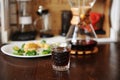 Breakfast with coffee. Trendy old fashioned crystal glass. Japanese omelet with avocado and greens on white plate. Manual