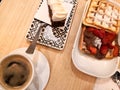 Breakfast of coffee, waffle with nutella and strawberries