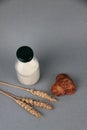 Breakfast concept - a bottle of milk, pile of cookies and ears of wheat on gray background