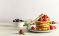 Breakfast concept with american pancakes with raspberries, blueberries, and honey