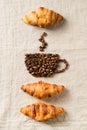 Breakfast concept with cup of coffee from coffee beans and croissants on table cloth texture Royalty Free Stock Photo