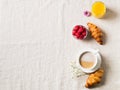 Breakfast concept with cup of coffee, croissants, berries, orange juice and flowers on cloth table Royalty Free Stock Photo