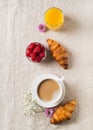 Breakfast concept with cup of coffee, croissants, berries, orange juice and flowers on cloth table Royalty Free Stock Photo