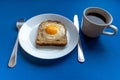 Breakfast concept. White plate with baked bread and egg and white coffee cup. Blue background Royalty Free Stock Photo
