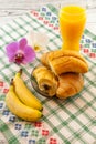 Breakfast consist of croissants filled with chocolate bananas and orange juice with orchid aside breakfast in bed concept