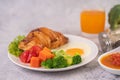 Breakfast consisting of bread, fried eggs, broccoli, carrots, tomatoes and lettuce on a white plate Royalty Free Stock Photo