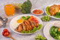 Breakfast consisting of bread, fried eggs, broccoli, carrots, tomatoes and lettuce on a white plate Royalty Free Stock Photo