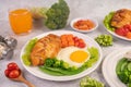Breakfast consisting of bread, fried eggs, broccoli, carrots, tomatoes and lettuce on a white plate Royalty Free Stock Photo