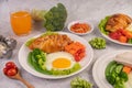 Breakfast consisting of bread, fried eggs, broccoli, carrots, tomatoes and lettuce on a white plate Royalty Free Stock Photo