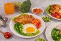 Breakfast consisting of bread, fried eggs, broccoli, carrots, tomatoes and lettuce on a white plate Royalty Free Stock Photo