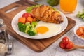 Breakfast consisting of bread, fried eggs, broccoli, carrots, tomatoes and lettuce on a white plate Royalty Free Stock Photo