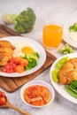 Breakfast consisting of bread, fried eggs, broccoli, carrots, tomatoes and lettuce on a white plate Royalty Free Stock Photo