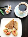 breakfast consists of avocado and salmon sandwiches and coffee on the table Royalty Free Stock Photo