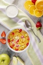 Breakfast cornflakes and strawberries with milk, yogurt and orange juice.