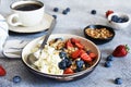 Breakfast - cottage cheese with berries and a cup of coffee, top view. Granola with nuts, honey and strawberries Royalty Free Stock Photo