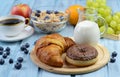 Breakfast with croissant, donut, coffee, cereal and fruits