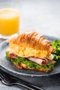 Breakfast croissant sandwich with turkey ham, scrambled eggs, cheese and lettuce salad Royalty Free Stock Photo