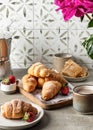 Breakfast with croissants, coffee, berries, peonies flower, honey composition with tile background Royalty Free Stock Photo