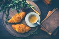 Breakfast - Croissants with nuts and cup of coffee on morning table