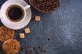 Breakfast A cup of coffee with pieces of cane sugar, biscuits with chocolate and a vase with coffee beans.