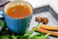 Breakfast. A cup of tea on a tray with a bunch of mint, starlets of anise and chopsticks of cinnamon