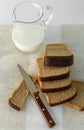 Breakfast. Dark sliced ??bread, knife and milk in a jug. Royalty Free Stock Photo