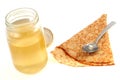 Jar of honey with a homemade crepe on a white background